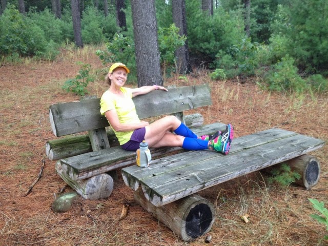Woman resting on bench in pine forest on Ice Age Trail near Chaffee Creek.