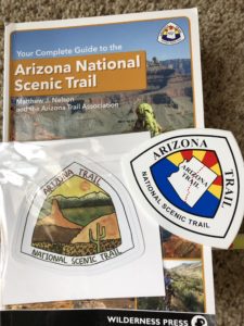 Arizona National Scenic Trail guidebook with two Arizona Trail stickers on top.