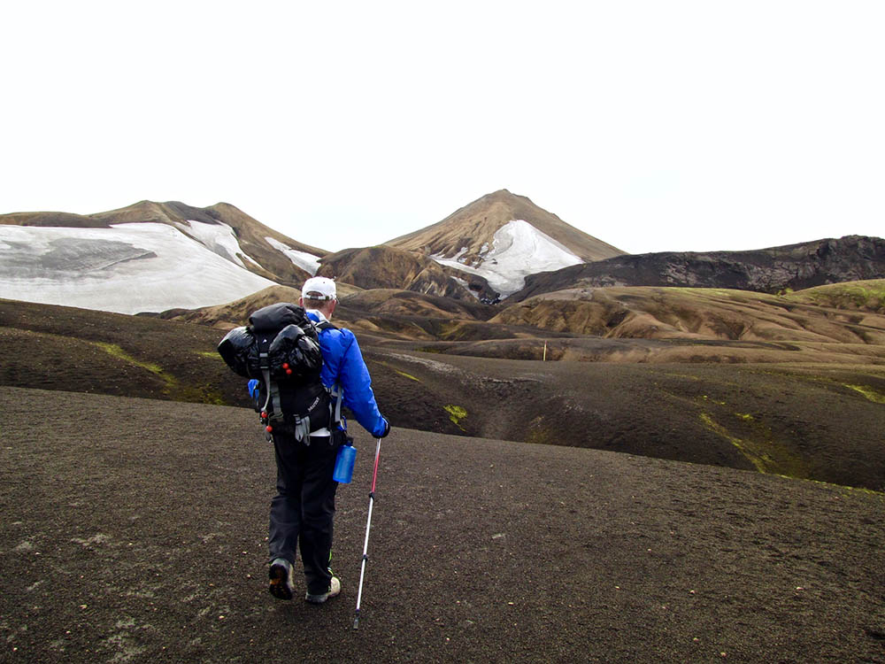 Backpacker hiking in lava debris in Iceland's Laugavegur Trail.