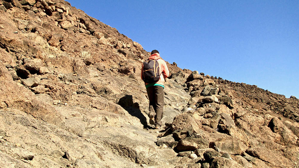 Man hiking up the volcanic Mt. Teide in the Canary Islands.