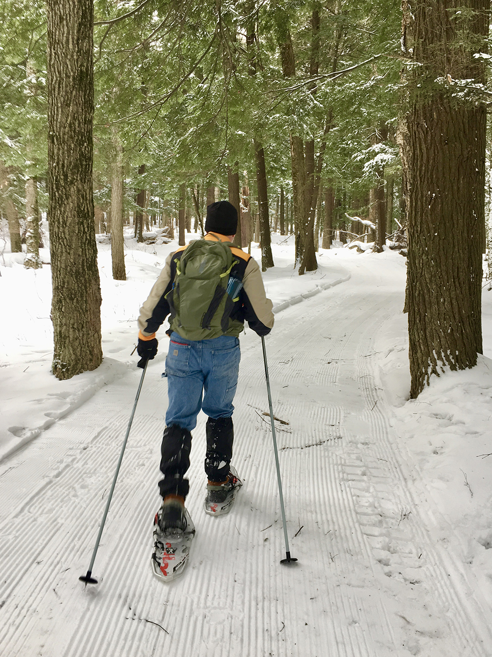 Man snowshoeing through a groomed trail in the Porcupine Mountains.