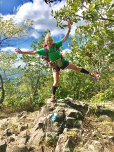 Woman hiker standing on one leg on a rock on New England Trail near Spruce Brook Road