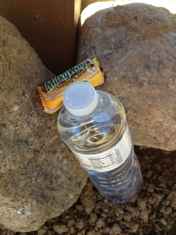 Bottle of water and snack-size candy bar tucked between two rocks on the Ice Age Trail near Ringle.