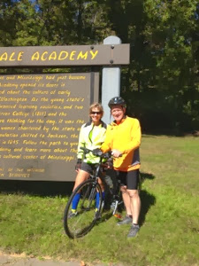 Two cyclists by a sign along the Natchez Trace.