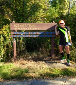 Woman standing by Ice Age Trail sign in Janesville