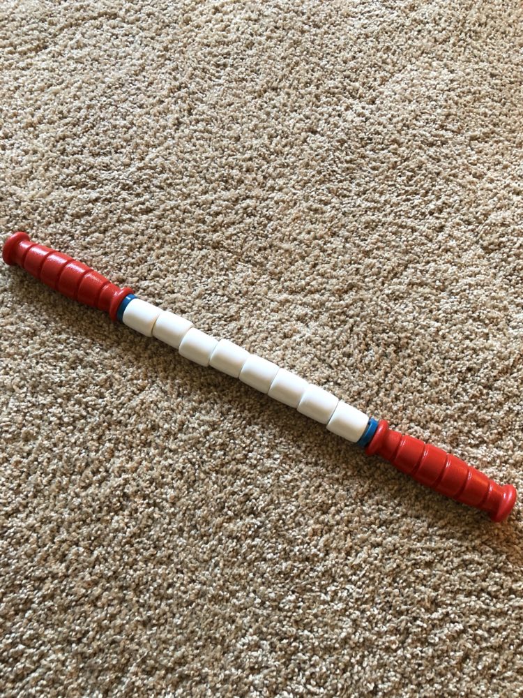 White muscle rolling stick with red ends that will be used on hike of 1200 miles