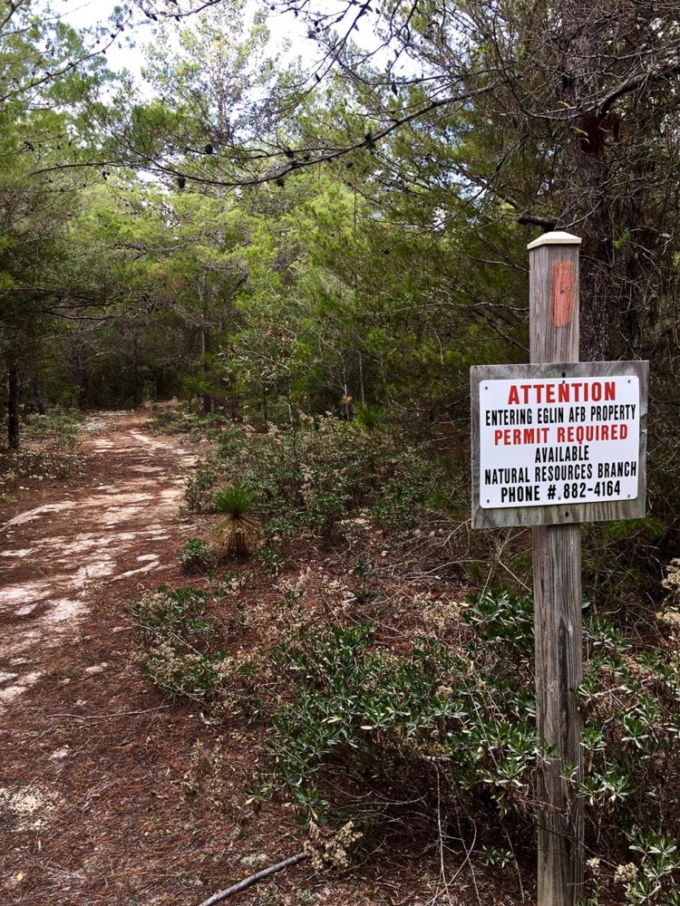 Sign next to hiking trail announcing entrance to Eglin Air Force Base