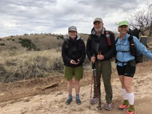 Three hikers standing on a dirt road leading to Tunnel Spring on the Arizona Trail.