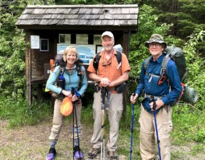 A woman and two men with backpacks getting ready to hike the Border Route Trail.