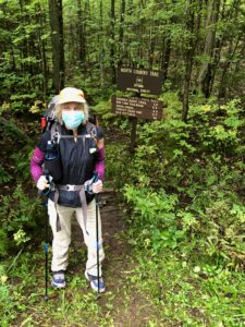 Female hiker with mask by North Country Trail sign at Hwy. 326
