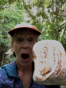 Woman holding up huge loaf of cinnamon bread on North Country Trail near Gardner Road.