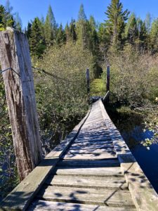 Very tilted wooden footbridge on the North Country Trail.