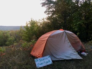 Orange-and-white tent on top of overlook with sign propped against tent saying Scenic Overlook.