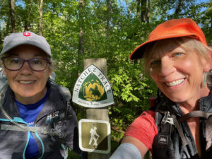 Two women hikers standing by Natchez Trace National Scenic Trail sign.