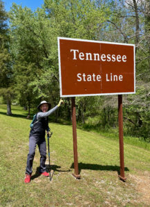 Female hiker by sign saying, 