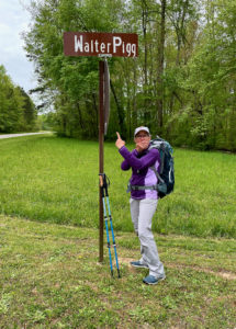 Female hiker by street sign saying, 