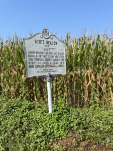 Sign about John Wilkes Booth next to a cornfield.