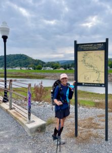Woman standing by C&O Canal Towpath sign.