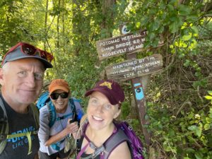 Three hikers standing by Potomac Heritage Trail sign near Scott’s Run.