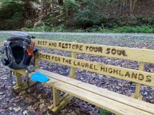 Wooden bench with a sign saying, “Rest and Restore Your Soul.”
