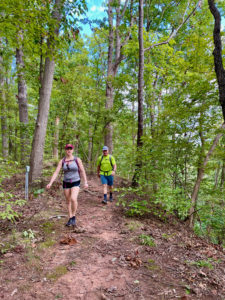 Woman and man hiking through the woods.