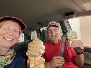 Man and woman in car with ice cream cones.