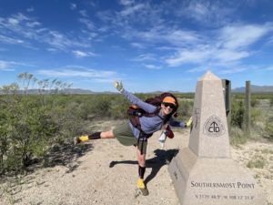 Woman standing by southern terminus marker for Continental Divide Trail.